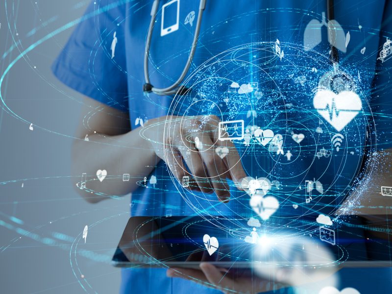 Health worker using tablet with medical and data icons